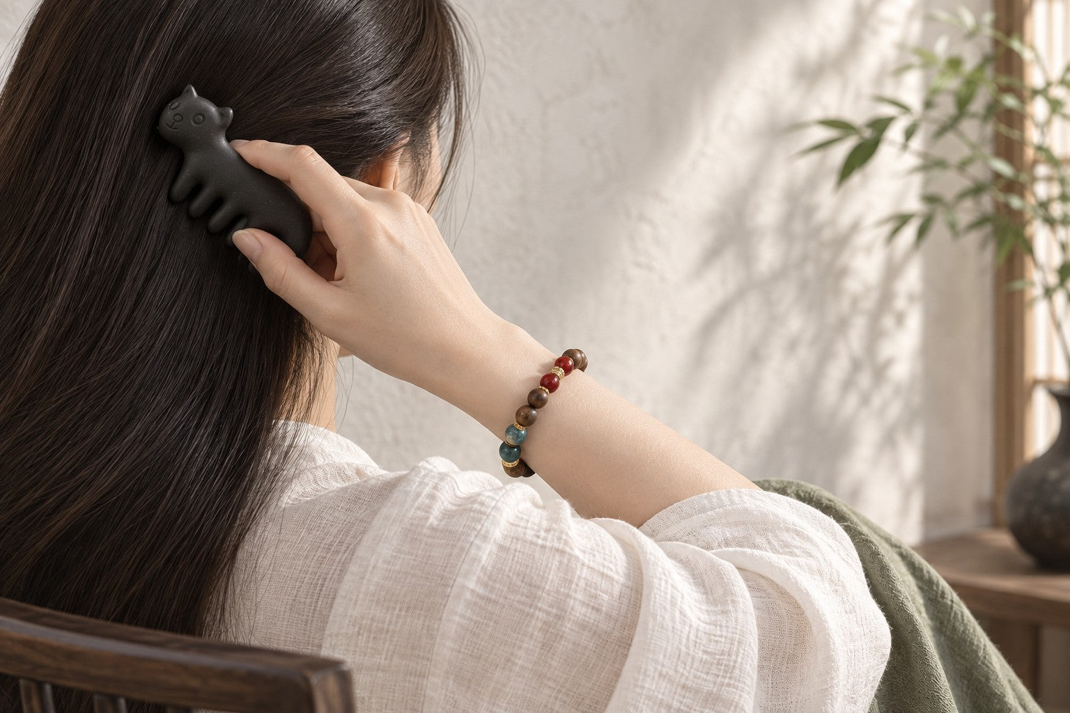 Woman wearing a He Xiang bracelet while using a bird-shaped He Xiang comb